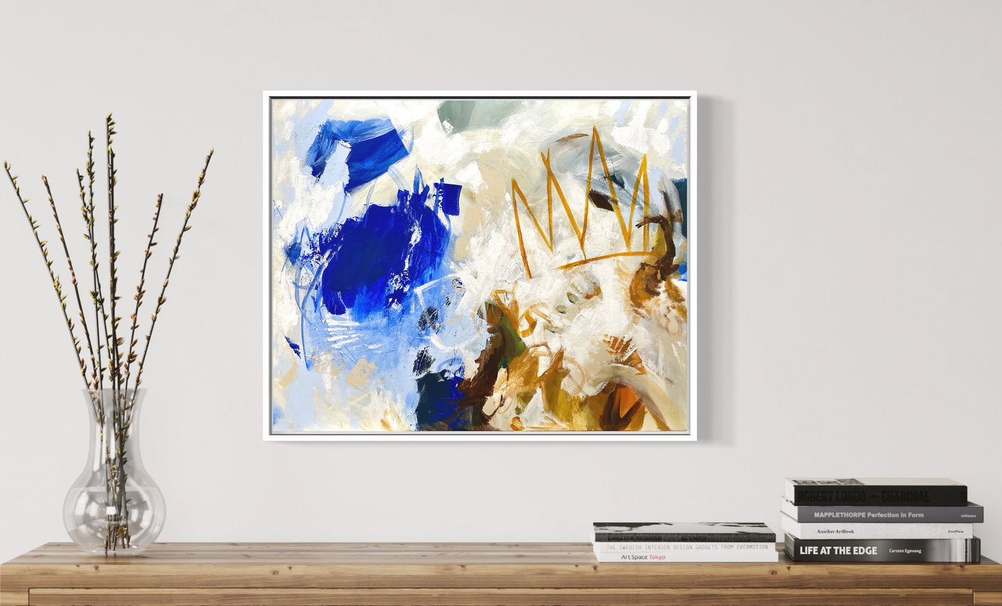 Blue abstract energetic painting with a crown icon. Abstract painting on a wall above a wooden console table with decorative items.