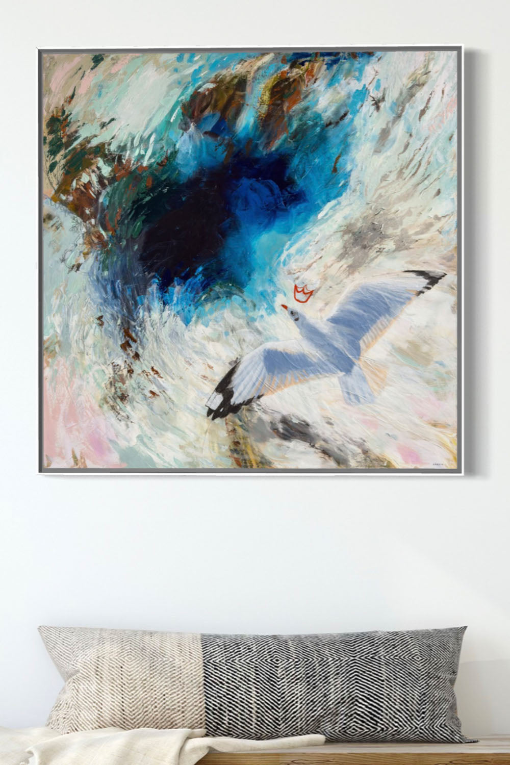 Framed abstract artwork of a crowned seagull flying painted by New England artist Megan Carty, on a wall with entryway bench below.