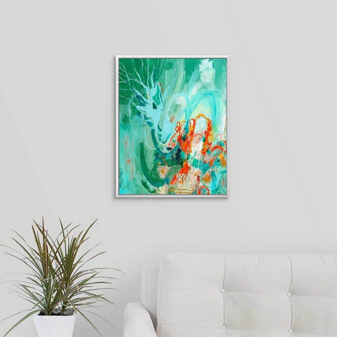 Framed green and orange abstract artwork on a wall above a sofa with a plant.