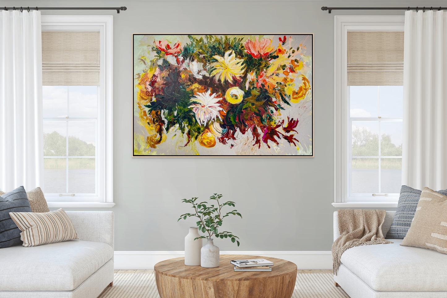 Living room with a warm colorful abstract floral painting by Megan Carty on the wall, white sofa, wooden coffee table, and decorative pillows.