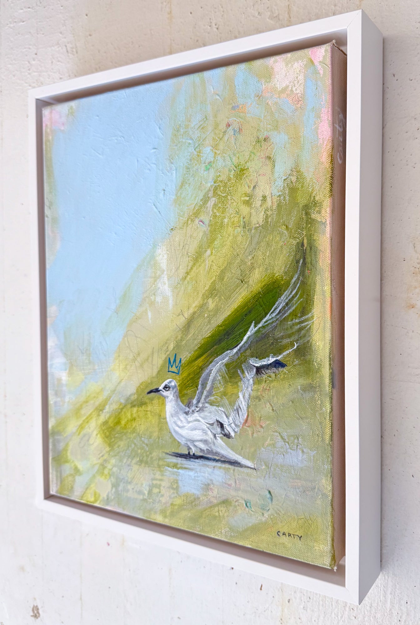 Framed painting of a white bird on a colorful background by Megan Carty