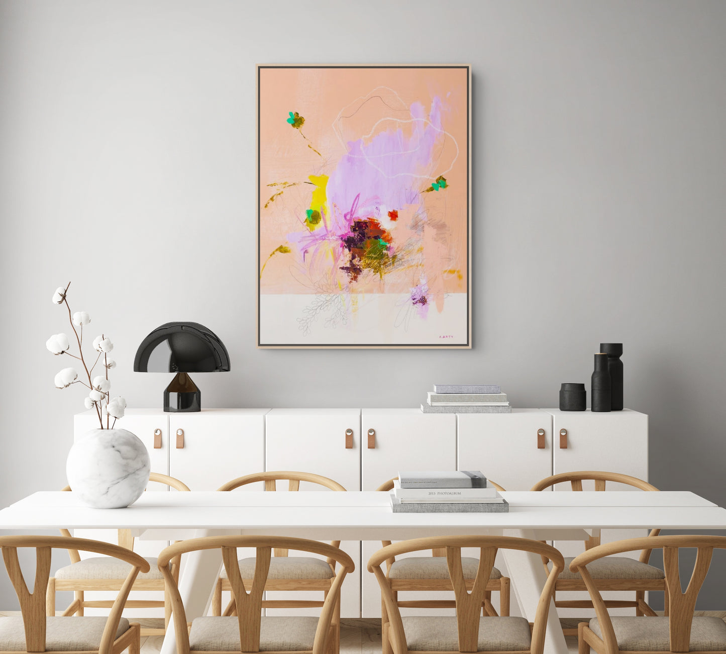 Dining room with a white table and chairs, a white cabinet, and colorful inuitive abstract art by Boston artist Megan Carty on the wall.